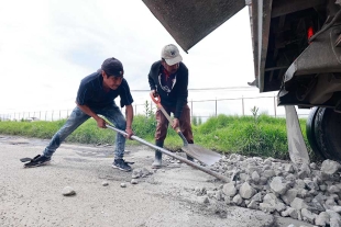 Trabajadores de la empresa de autotransportes Atzuzi se han dado a la tarea de tapar los baches