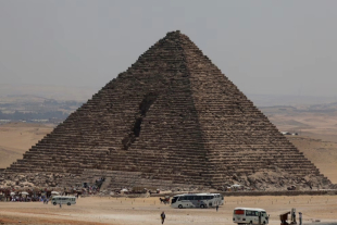 Turistas se reúnen frente a la pirámide de Menkaura, donde nuevos estudios revelaron posibles cavidades que podrían indicar una entrada aún desconocida en la estructura más pequeña de Giza.